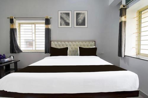 a large white bed in a bedroom with windows at Hotel Crystal INN in Bhubaneshwar