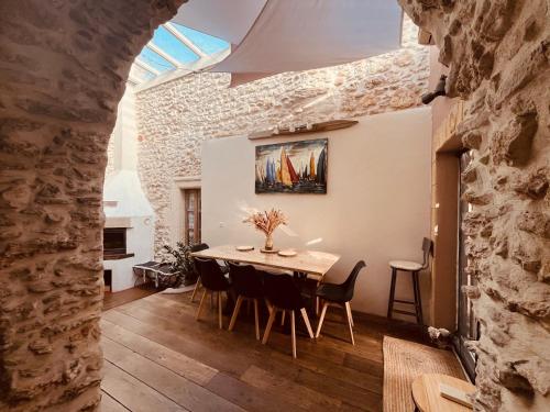 une cuisine et une salle à manger avec une table et des chaises dans l'établissement La maison du Bougainvillier 10 personnes, à Dions
