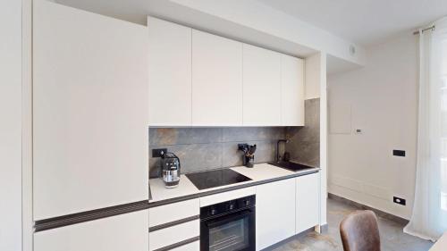 a kitchen with white cabinets and a sink at Il Rifugio sul Fiume in Cassano dʼAdda