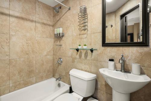 a bathroom with a sink and a toilet and a bath tub at Heart of NY, Steps away from all Attractions in New York
