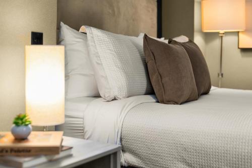 a bed with pillows and a table with a lamp at Heart of NY, Steps away from all Attractions in New York