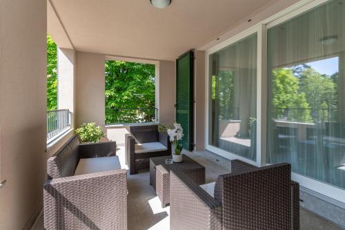 a screened porch with chairs and tables and windows at Il Rifugio sul Fiume in Cassano dʼAdda