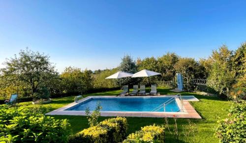a swimming pool in a yard with two umbrellas at Bizim Ev in Sapanca