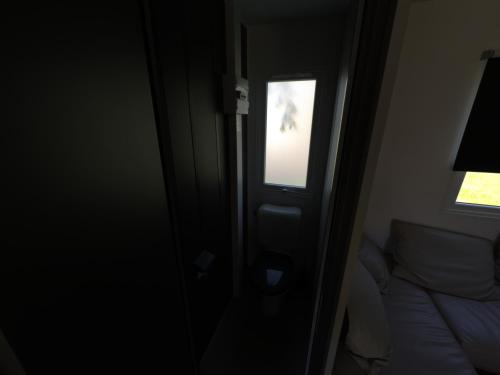 une porte avec une fenêtre dans une chambre avec un lit dans l'établissement Mobil-Home tout équipé, à Pont-Noyelles