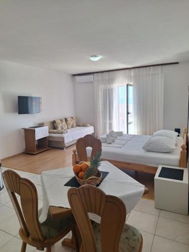 a living room with a table and chairs and a bedroom at Apartments Dalmacija in Podstrana