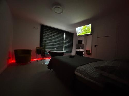 a dark room with a bed and a television at New Apart Smart- OAZA RELAKSU-Rynek Central Kielce - Parking -fak VAT- rok budowy 2025 in Kielce