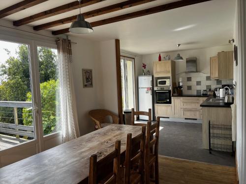 une cuisine avec une table et une grande fenêtre dans l'établissement Moulin de la Fosse Soucy 