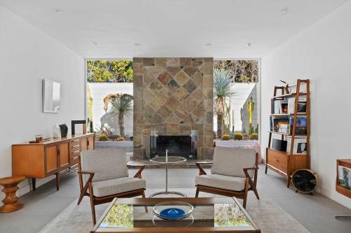 パーム・スプリングスにあるBelden Crist House Downtown Walkの暖炉とテーブルと椅子のあるリビングルーム