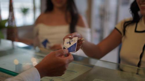 a person holding up a piece of paper on a glass table at Hotel H53 in Sogamoso