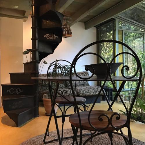 une chambre avec deux chaises, une table et des escaliers dans l'établissement La verrière, à Arles