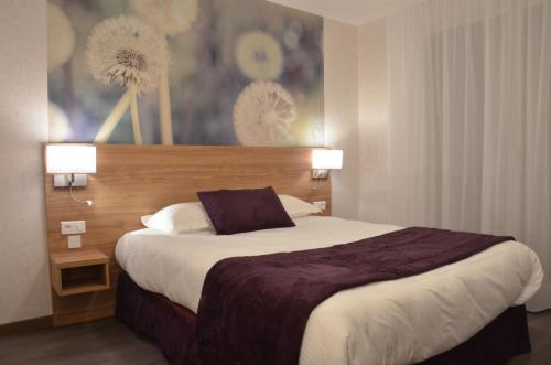 a hotel room with a large bed with two lamps at Logis Hôtel - La Chambre d'Amiens in Amiens