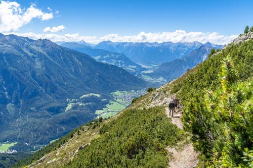 a person walking on a trail on a mountain at Gasthof Waldesruh in Oetz