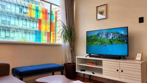 Una sala de estar con un televisor de pantalla plana sobre una cómoda. en Steps from Costanera Center, en Santiago