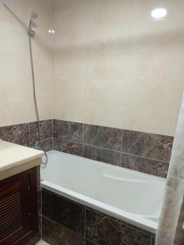 a bathroom with a bath tub and a sink at Elegant apartment in Rabat in Rabat
