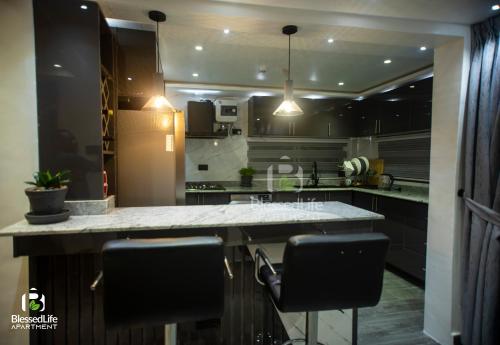 a kitchen with a counter and some black cabinets at Blessed life Apartments in Kumasi