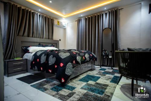 a bedroom with a bed with a black comforter at Blessed life Apartments in Kumasi