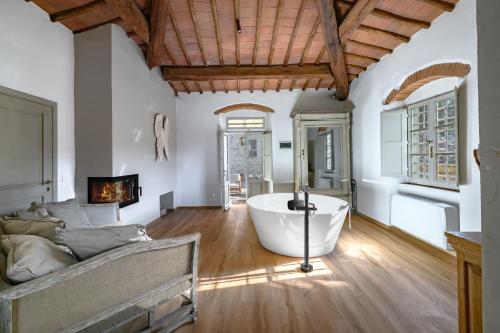 a large room with a bath tub and a couch at Il Casello Country House in Greve in Chianti
