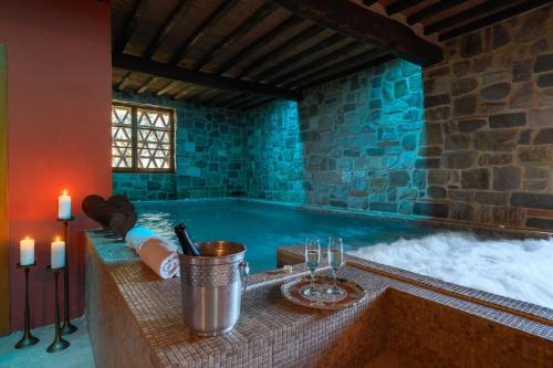a jacuzzi tub in a room with a stone wall at Il Casello Country House in Greve in Chianti