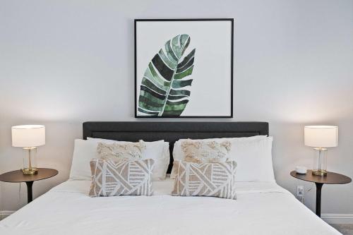 a bedroom with a white bed with two lamps at Antigua Villa - Volleyball - Pool - 5Bd in Indio