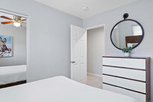 a white bedroom with a mirror and a white dresser at Antigua Villa - Volleyball - Pool - 5Bd in Indio