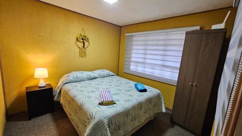 a small bedroom with a bed and a window at Lodge playa pupelde, Ancud in Mecura