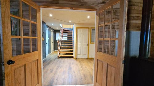 a room with wooden doors and a staircase in a house at Lodge playa pupelde, Ancud in Mecura