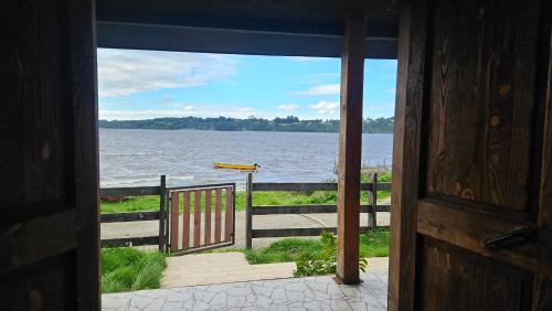 an open door to a view of a body of water at Lodge playa pupelde, Ancud in Mecura