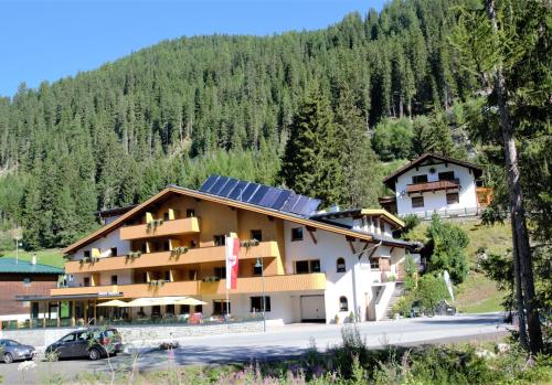 a building with solar panels on the side of a mountain at Gasthof Waldesruh in Oetz