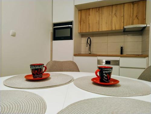 two coffee cups sitting on top of a table at Emari - Hochwertige 2-Zimmer-Wohnung mit Panorama Bergblick in SJJ