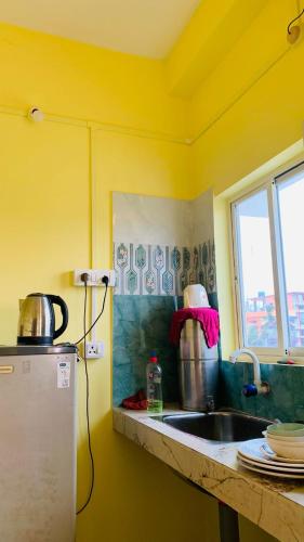 a kitchen counter with a sink and a window at Windchime9 in Guwahati