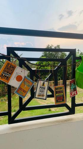 a window with signs hanging on a fence at Windchime9 in Guwahati