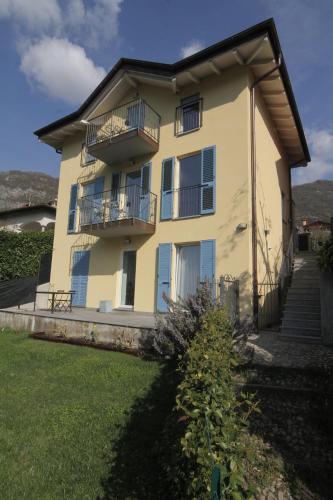 a large yellow house with a balcony and stairs at Maison Mimi apartments in Ossuccio