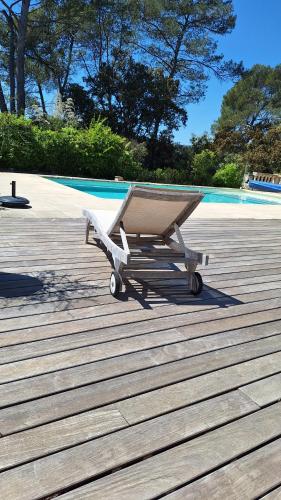 a cart sitting on a deck next to a pool at Villa Sisyphe chambre d'hôtes "la Mariette" in Le Thoronet