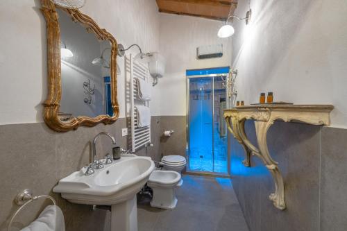 a bathroom with a sink and a toilet and a mirror at Il Casello Country House in Greve in Chianti