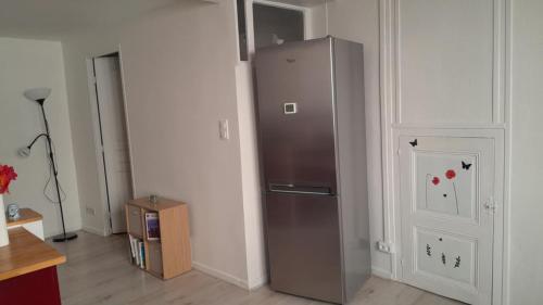 une cuisine avec un réfrigérateur en acier inoxydable dans une pièce dans l'établissement studio du cheylard le coquelicot, au Cheylard