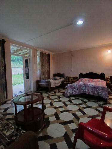 una sala de estar con un sofá y una mesa en Martvili Canyon Cottage by the River, en Martvili