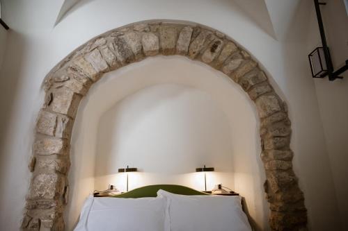 a bedroom with a stone arch with two pillows at Vicolo Effe in Terracina