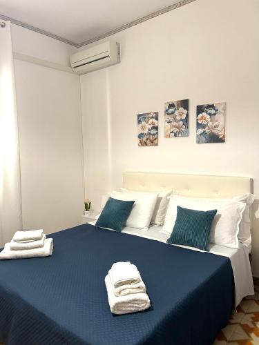 a bedroom with a blue bed with towels on it at Casa Puglia in Giardini Naxos