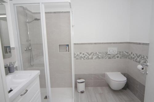 a white bathroom with a shower and a toilet at Maison Mimi apartments in Ossuccio