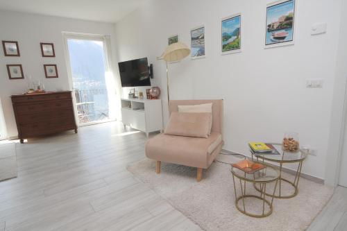 a living room with a chair and a television at Maison Mimi apartments in Ossuccio