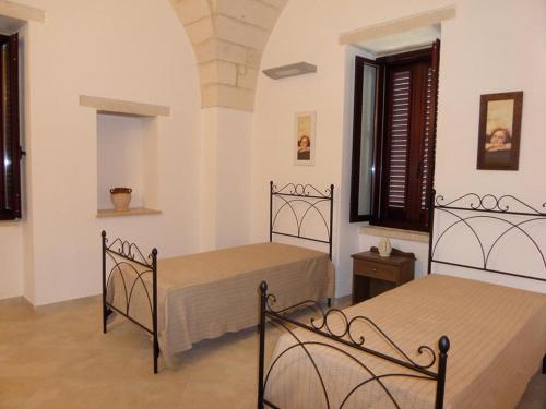 a bedroom with two beds in a room at Masseria Bosco Mazza in Melendugno
