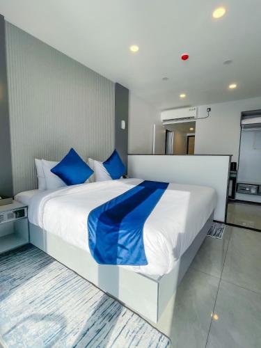 a bedroom with a large white bed with blue pillows at iCom Blue Seaview in Maafushi
