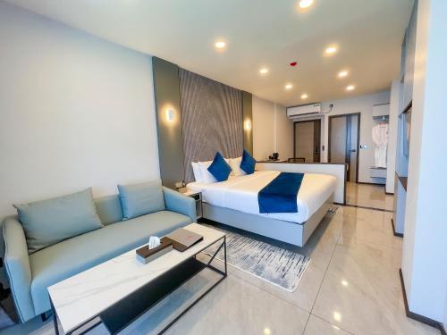 a hotel room with a bed and a couch at iCom Blue Seaview in Maafushi