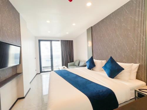 a hotel room with a large bed and a television at iCom Blue Seaview in Maafushi