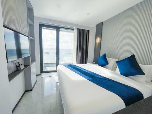 a hotel room with a large bed with blue pillows at iCom Blue Seaview in Maafushi