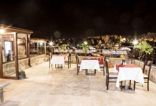 a restaurant with tables and chairs at night at Peace Stone House in Goreme