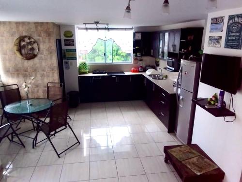 a kitchen with a table and a refrigerator and a table and chairs at Moderno Apartamento completo 3piscinas 2jacuzzi y Playa cerca in Tonsupa