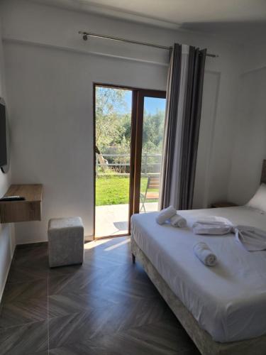 Un dormitorio con una cama y una puerta corrediza de vidrio. en Vila Cano, en Sarandë