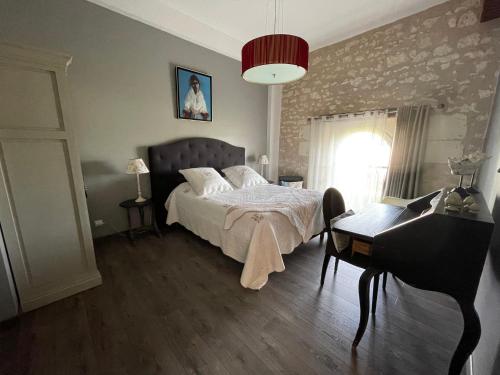 une chambre avec un lit, une table et un piano dans l'établissement Gite du Domaine de la Maison Neuve, à Saint-Jean-Saint-Germain