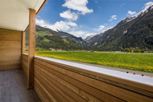 a balcony with a view of a field and mountains at Chalet S Apartments in Campo Tures
